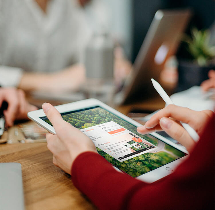 Person using a tablet to manage the European Minimum Wage Law through the Copilot platform.